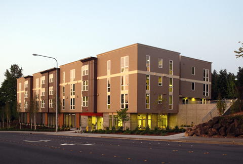A large building with a lot of windows is lit up with yellow lights.
