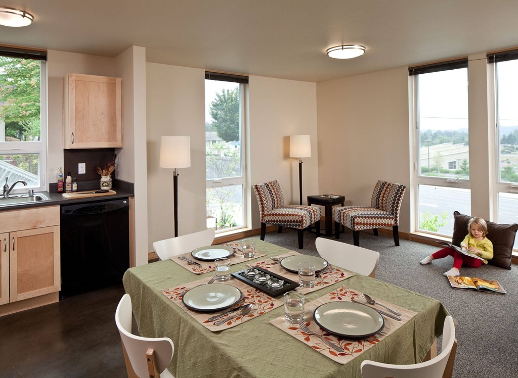 A dining room with a table set for a meal.