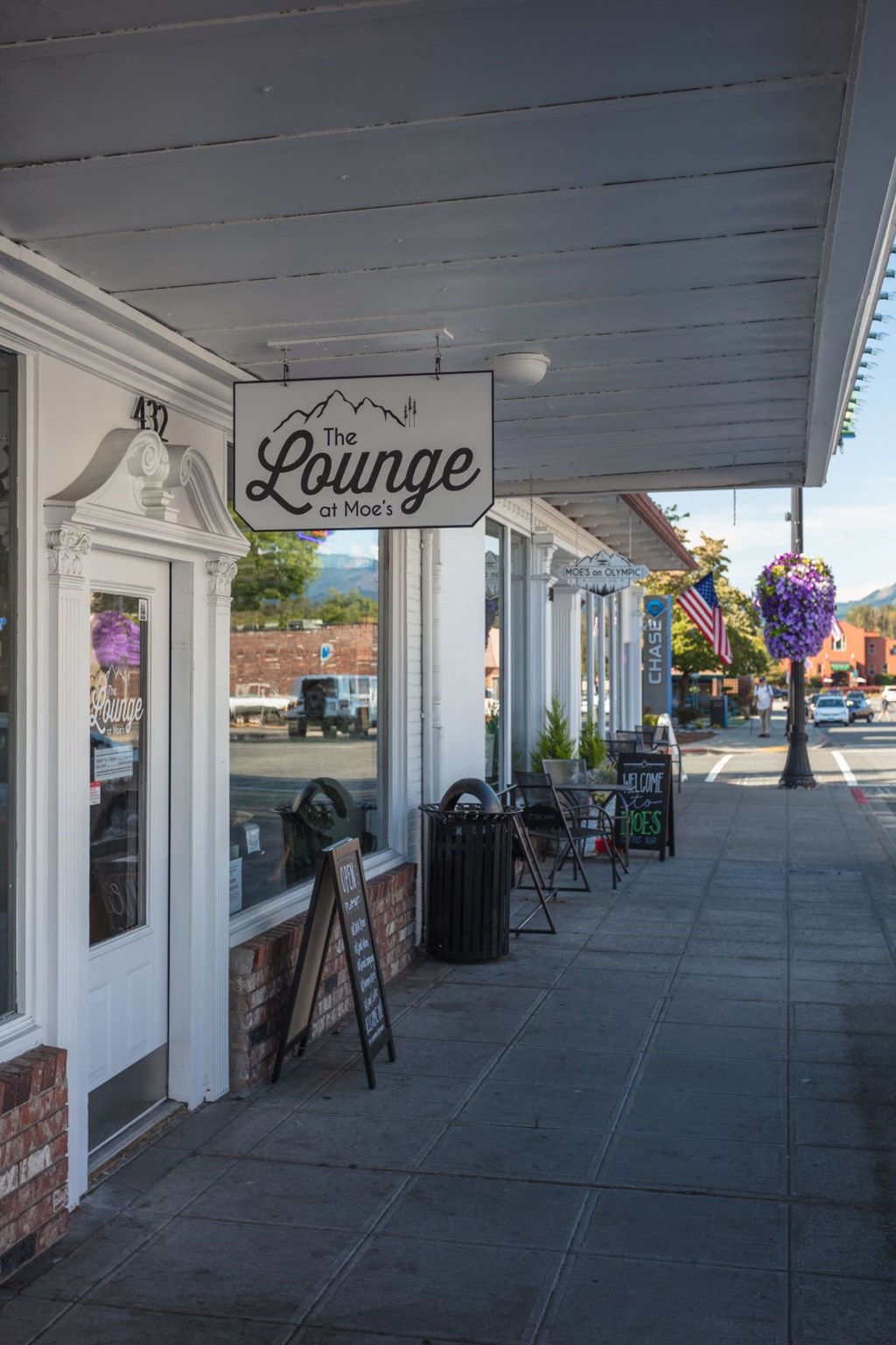 a sign hanging on the side of a building on a sidewalk