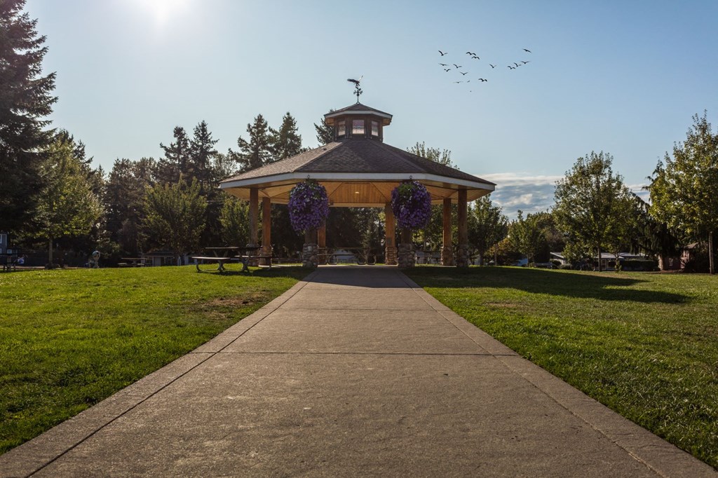 a gazebo with purple wreaths on it in a park