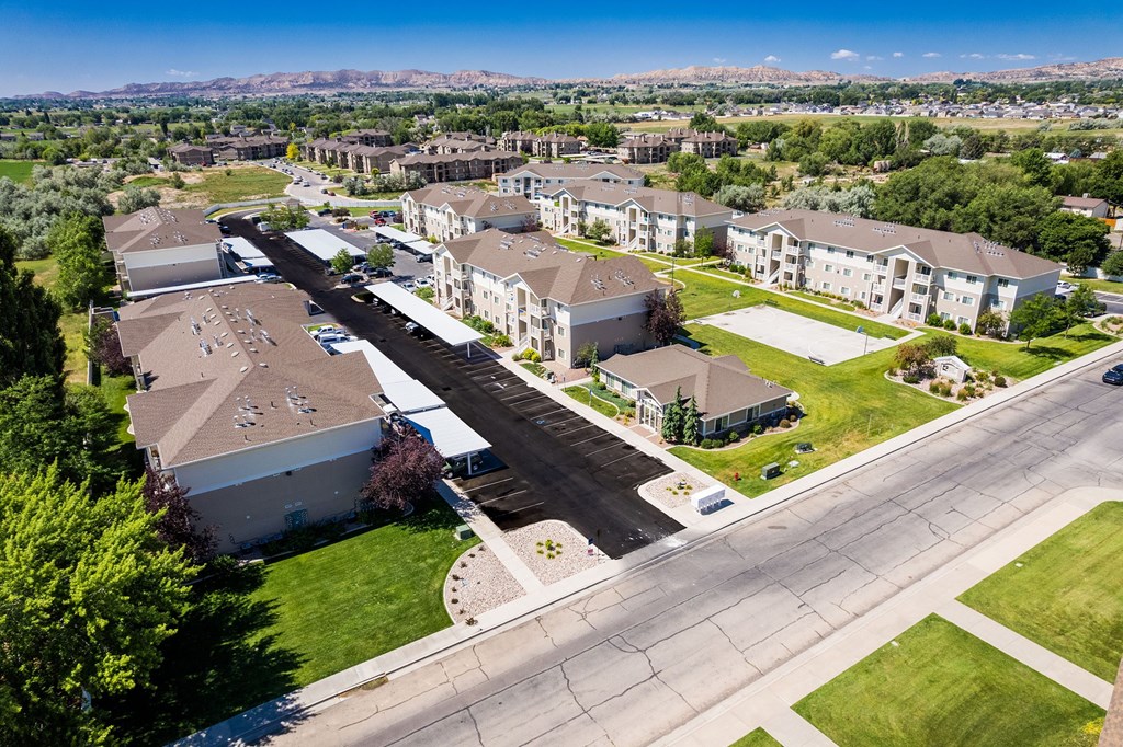 A large apartment complex with a parking lot in front.