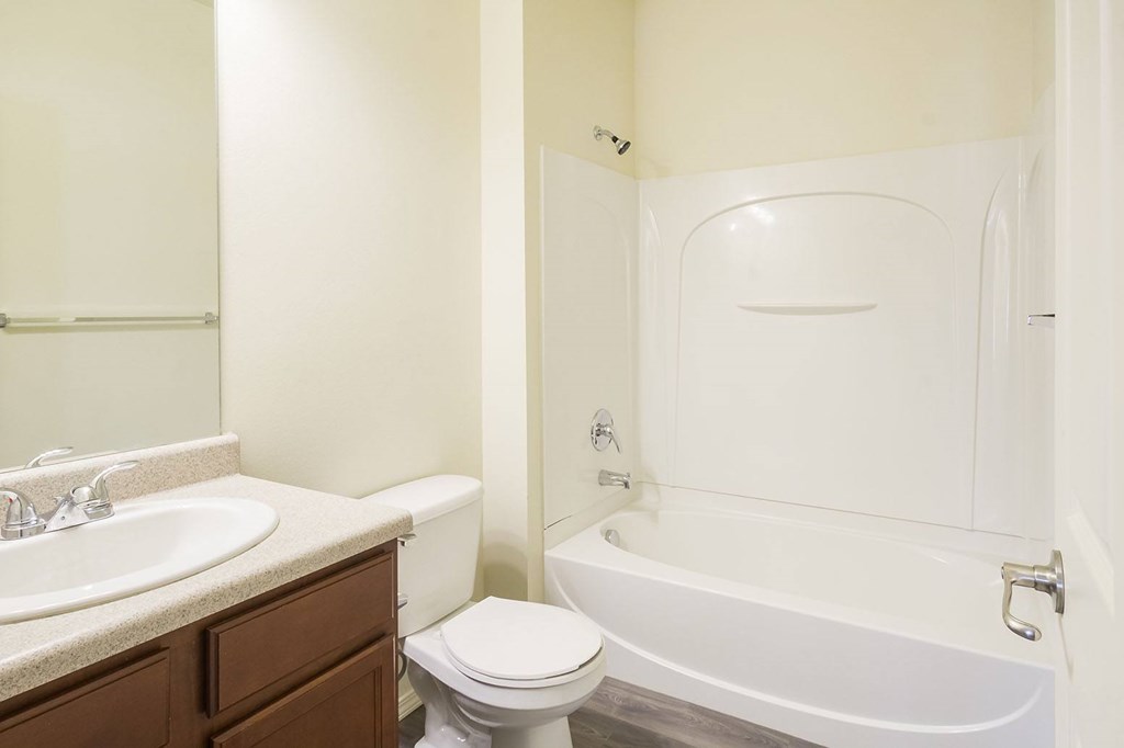 A white bathroom with a toilet, sink, and bathtub.