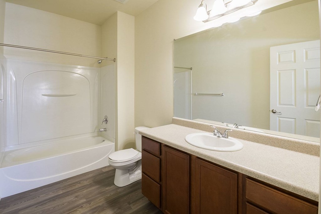 A white bathroom with a toilet, sink, and bathtub.