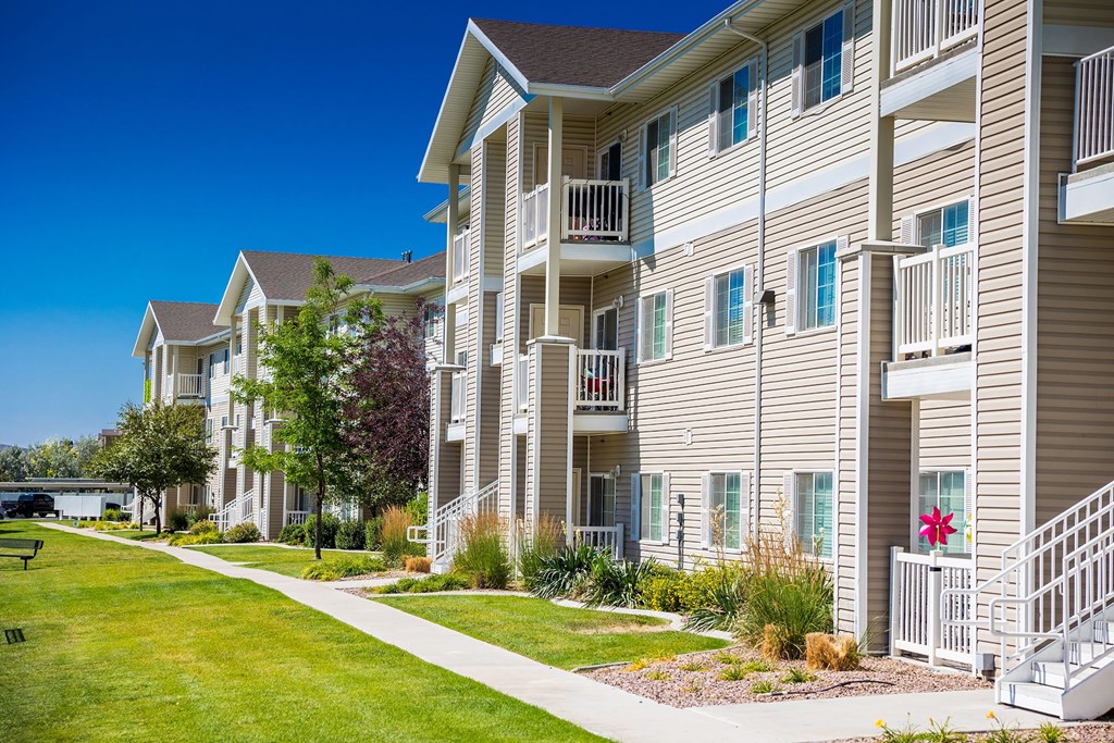 A row of apartment buildings with a clear blue sky above.