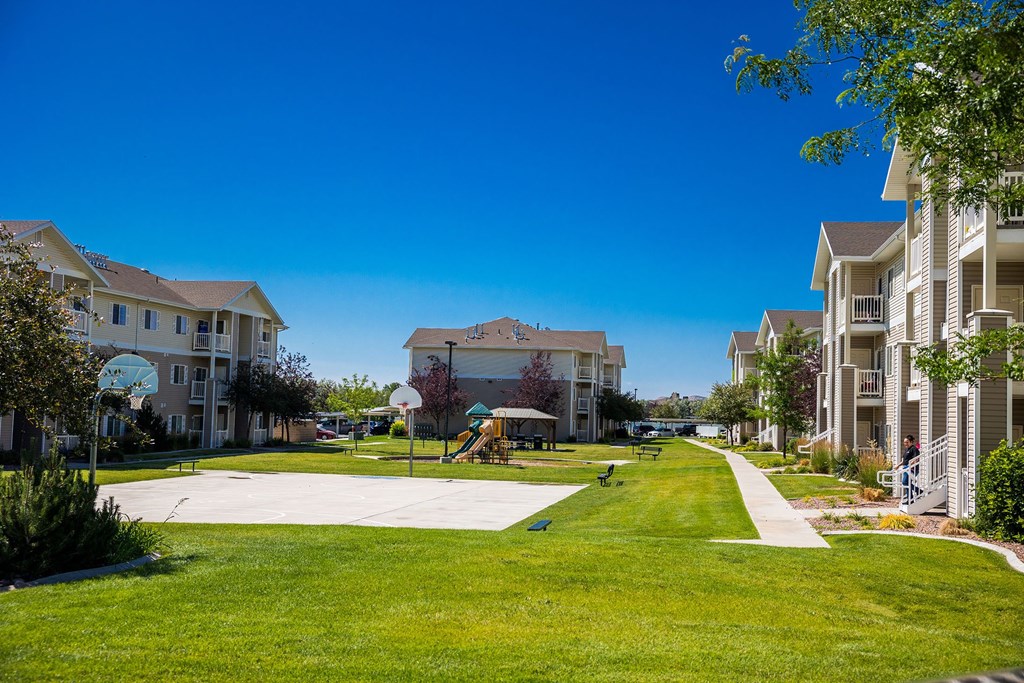 A sunny day at a residential complex with a playground in the middle.