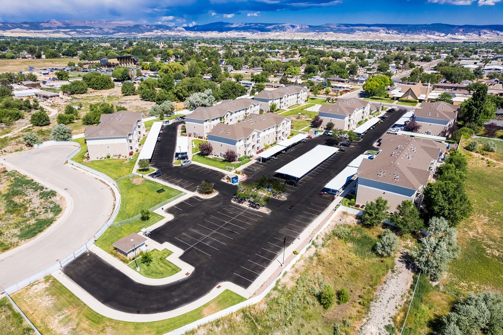 A large parking lot is surrounded by apartment buildings.