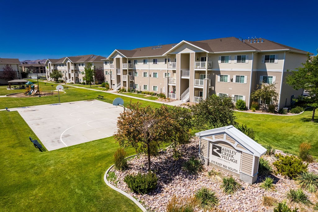 A view of a Shelby Village apartment complex with a playground and a sign.