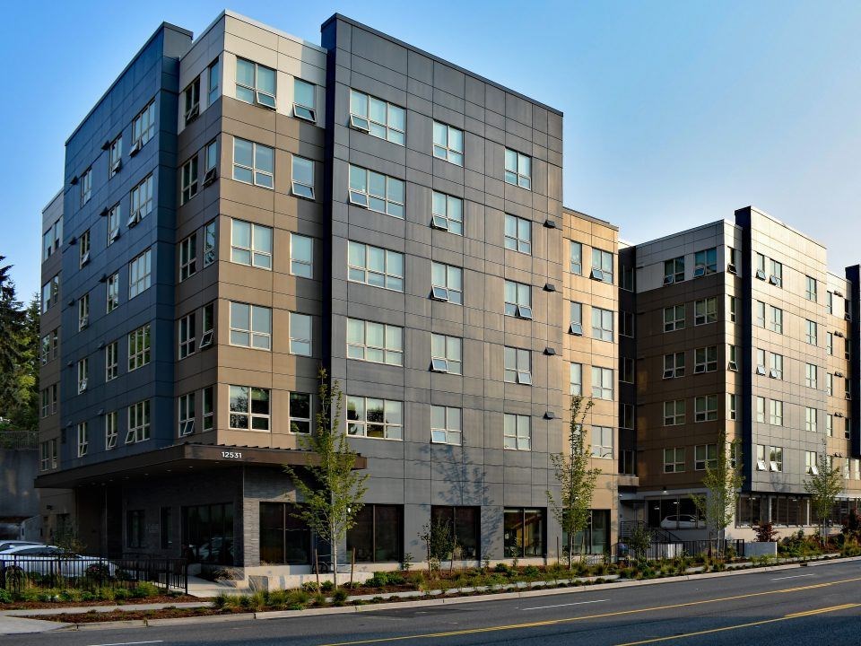 A modern multi-story building with a mix of dark and light brown panels.