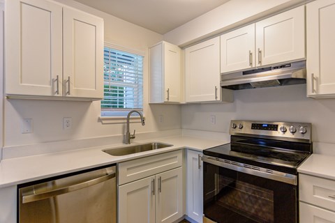 A kitchen with white cabinets and a black stove top oven.