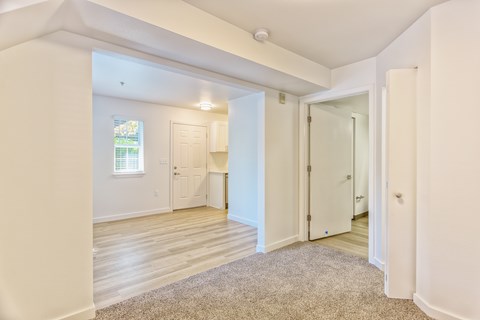 A room with white walls and a window with blinds.