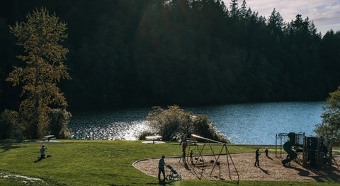 A park with a playground and people enjoying the outdoors.