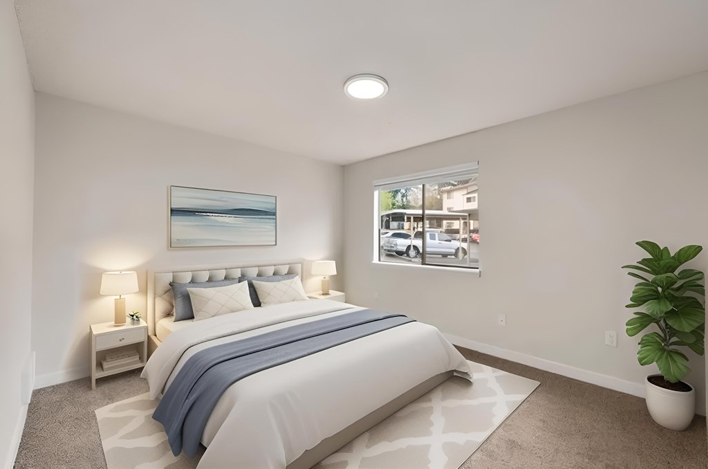 A bedroom with a large bed and a potted plant.