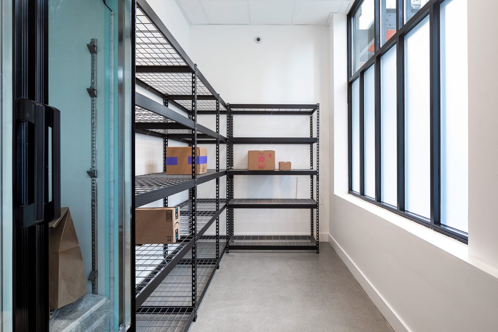 a room with some shelves and boxes in it and a window