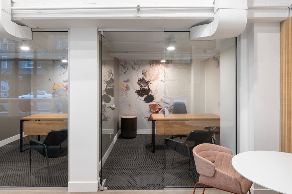 a conference room with tables and chairs and a glass wall