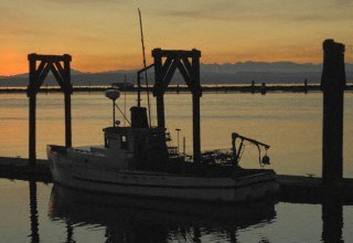 a small boat sitting in the water at a dock