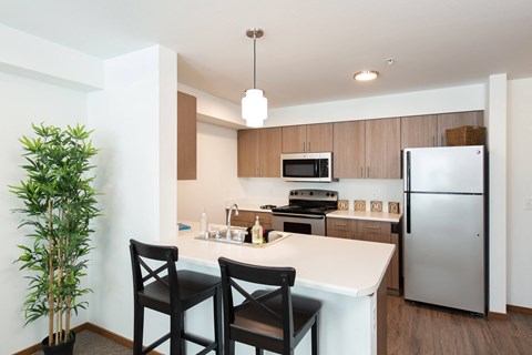 a kitchen with a white counter top and a stainless steel refrigerator