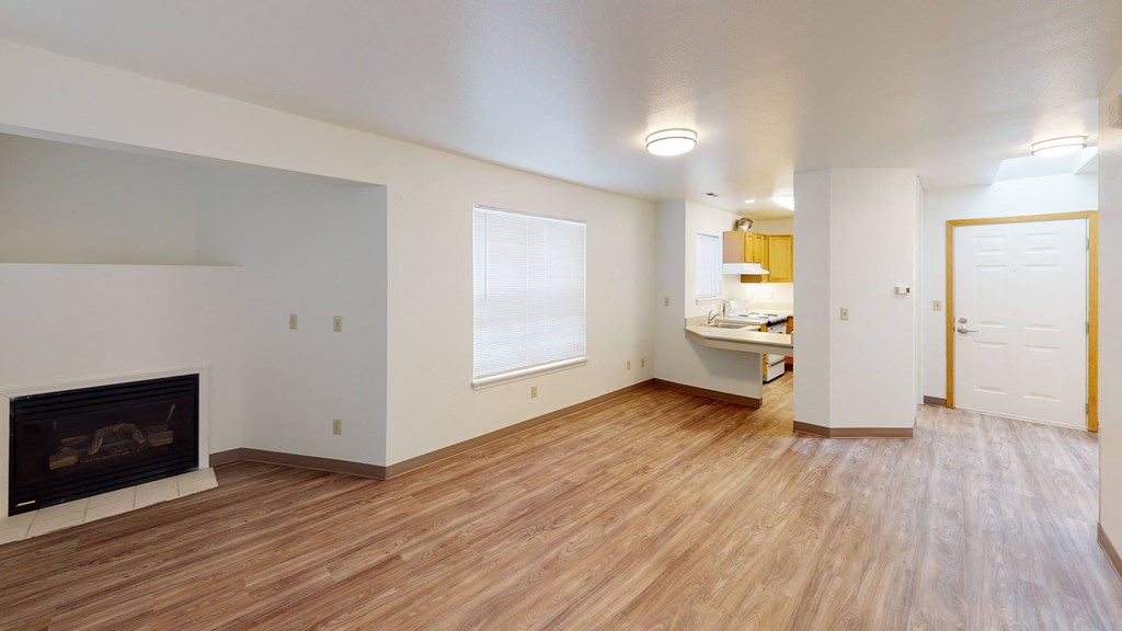 a living room with a fireplace and wooden floors