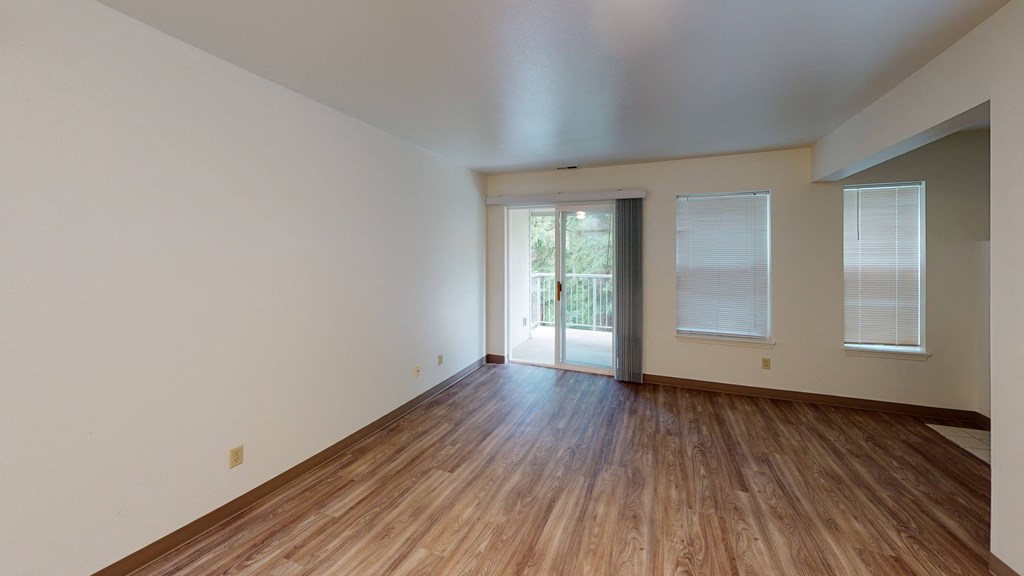 the living room of an empty house with wood floors and white walls