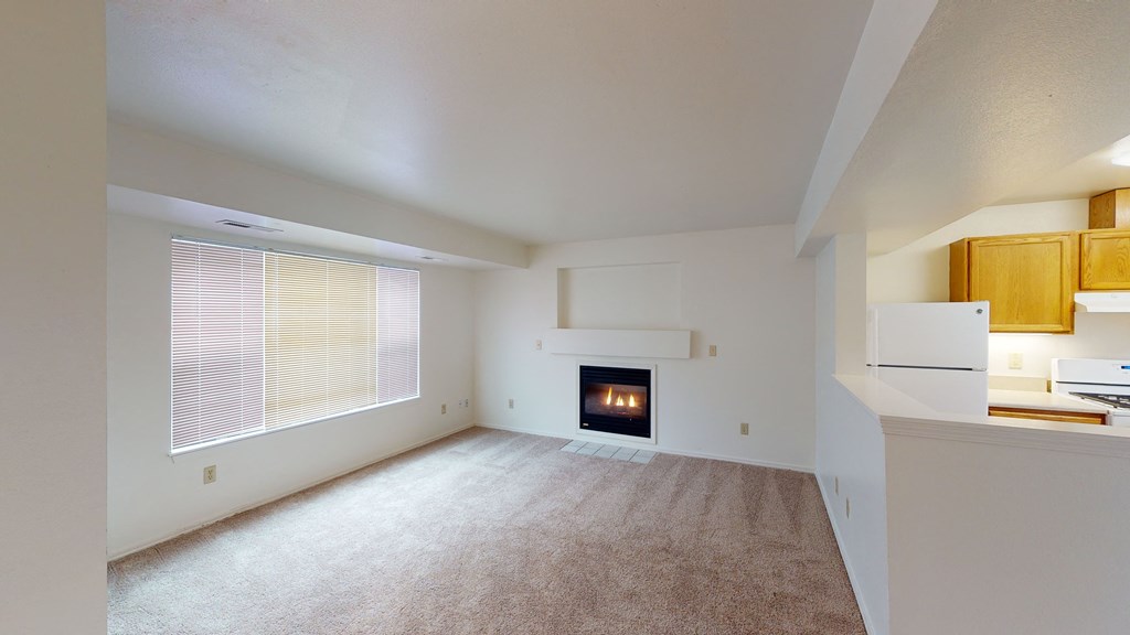 an empty living room with a fireplace and a window