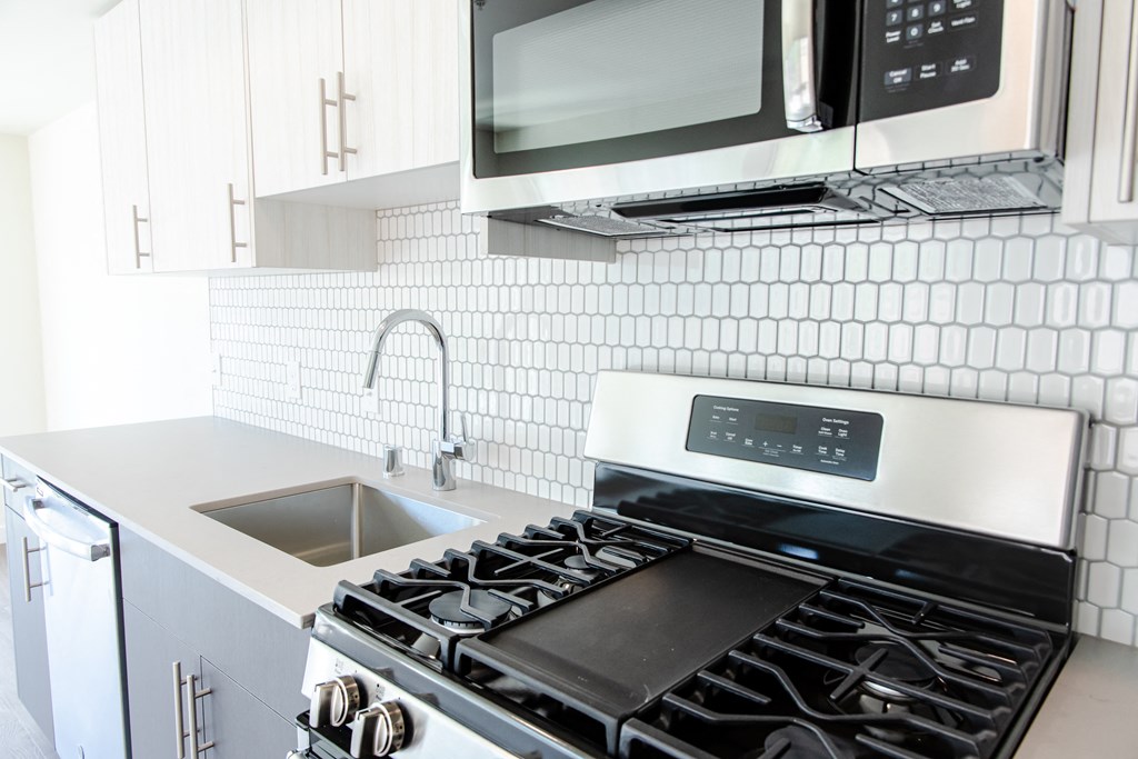 a white kitchen with a stove and a sink