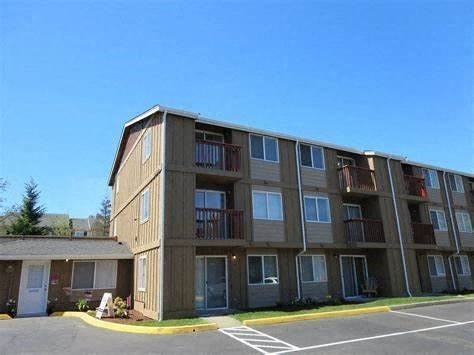 an apartment building with balconies and a parking lot