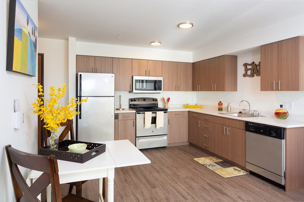 a kitchen with stainless steel appliances and a white table