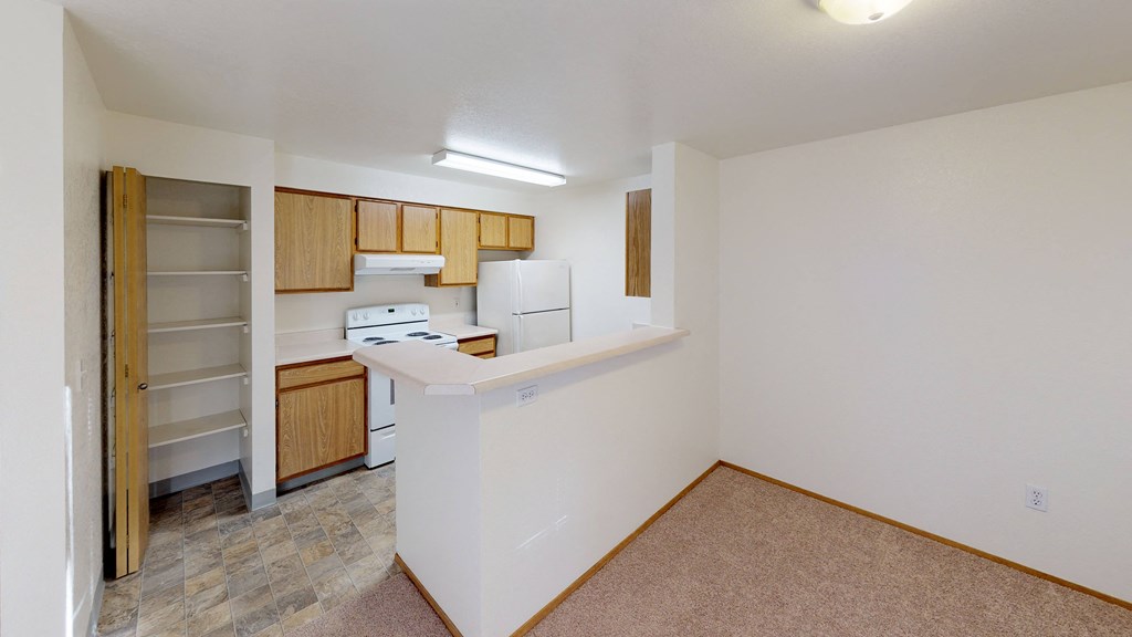 a kitchen with a counter and a refrigerator and a pantry