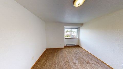 an empty room with carpet and a window
