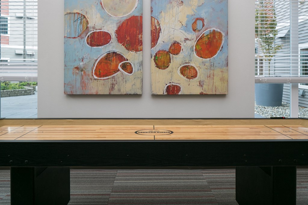 two paintings hanging on a wall above a table