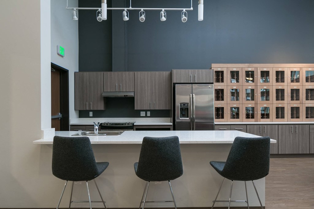 a kitchen with a counter and three chairs