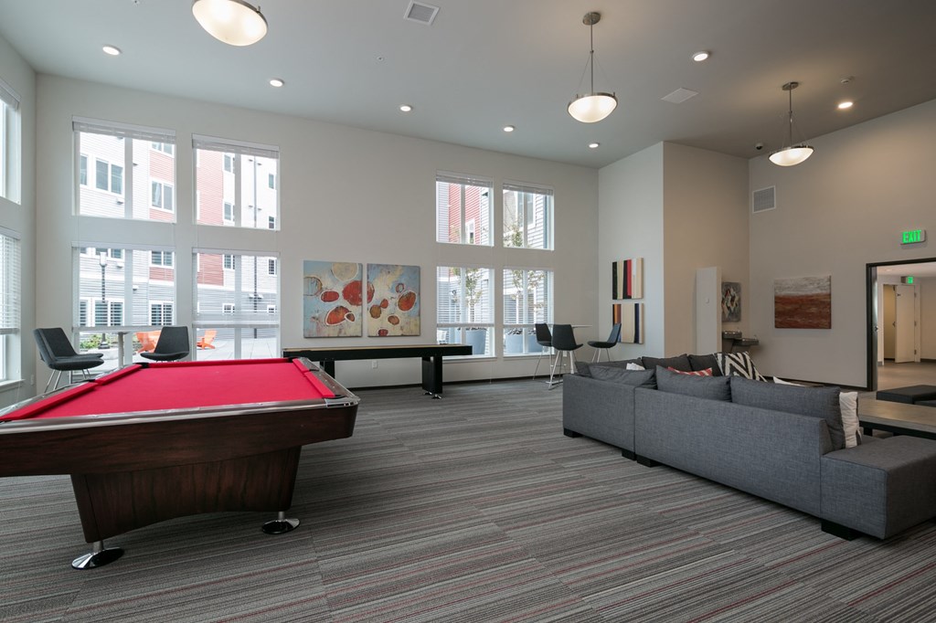a clubhouse with a pool table and couches