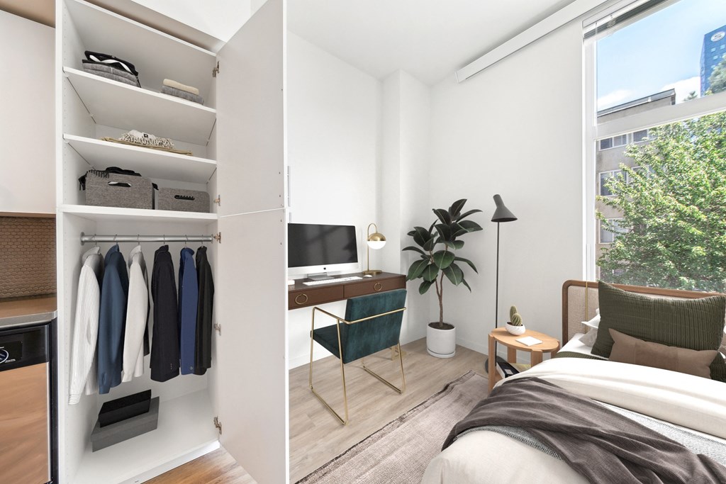 a bedroom with a desk and a closet and a window
