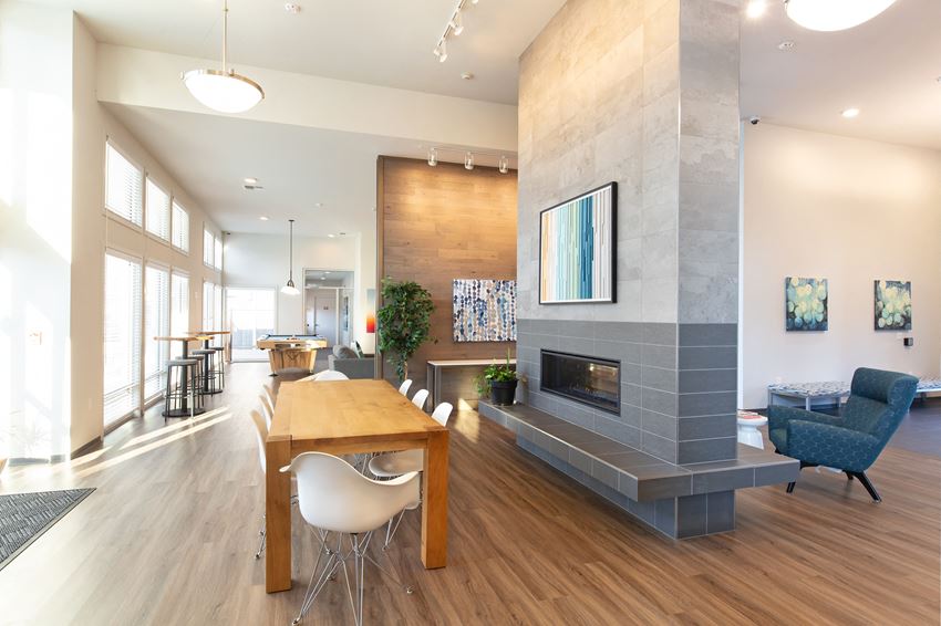 a living room with a fireplace and a wooden table and chairs