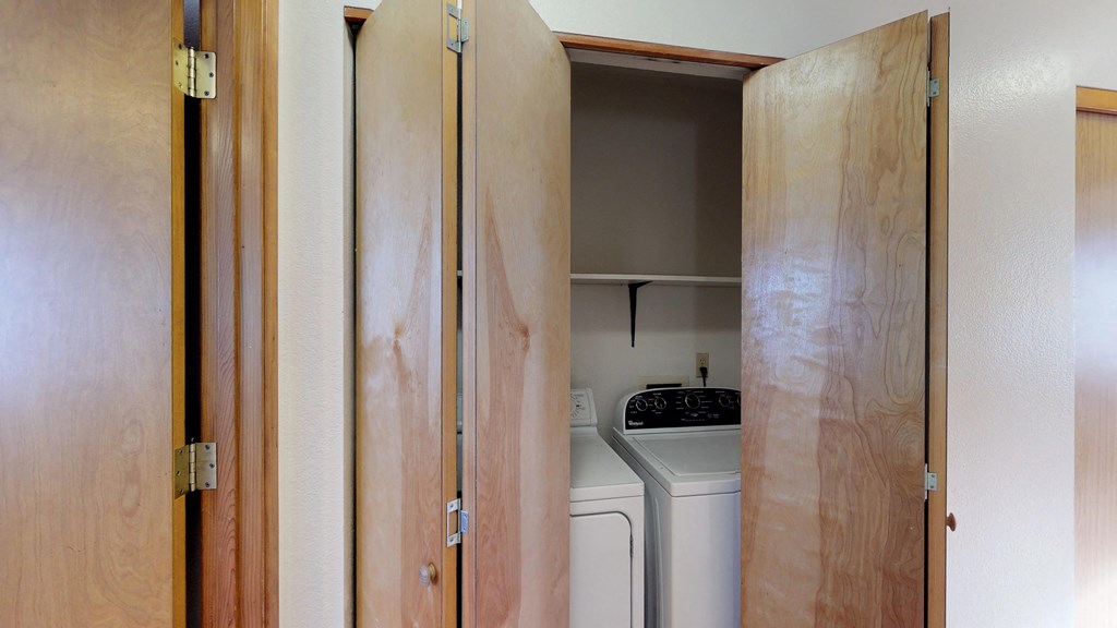 a laundry room with wood cabinets and a washer and dryer