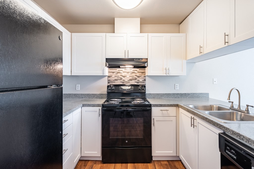 a kitchen with white cabinets and black appliances