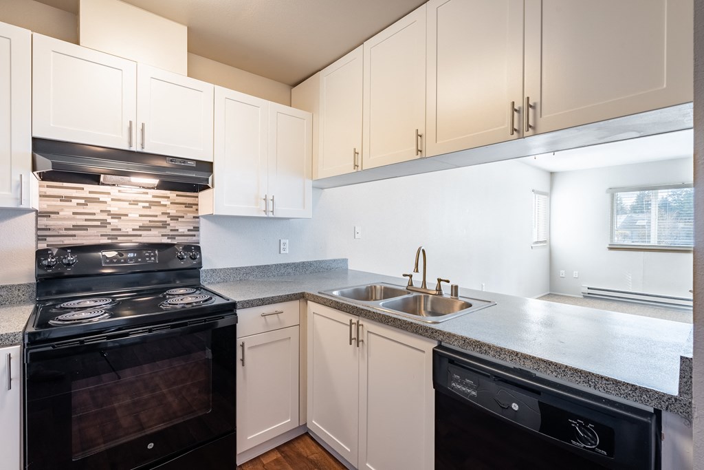 a kitchen with white cabinets and black appliances