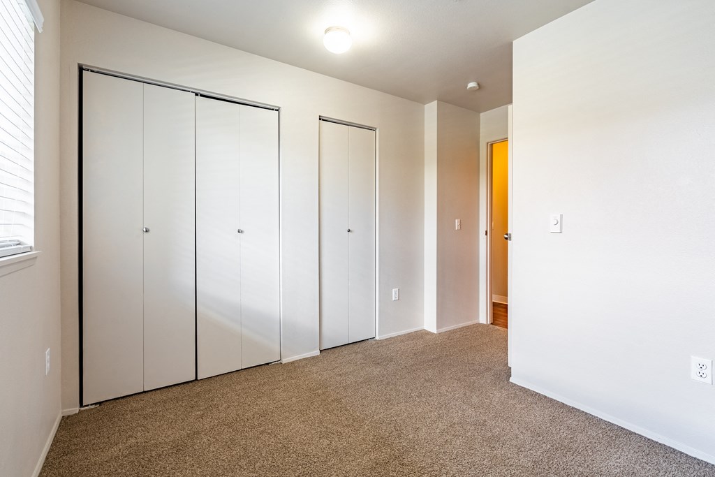 a bedroom with white walls and carpet