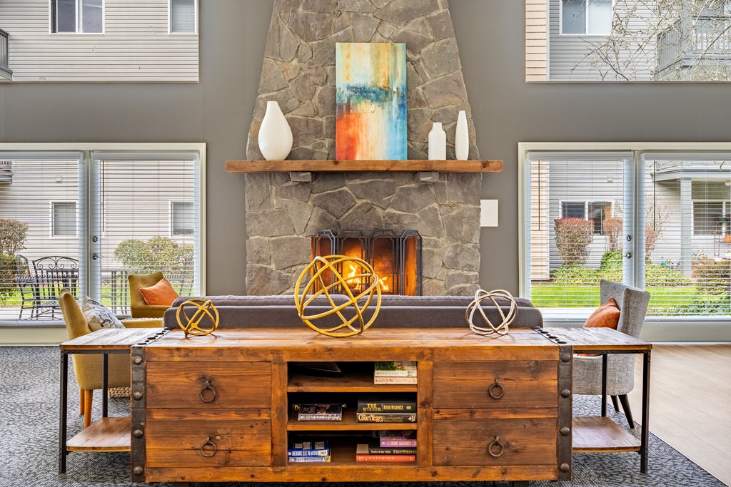 a living room with a large stone fireplace and a wooden entertainment center