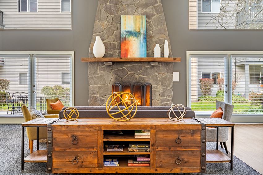 a living room with a large stone fireplace and a wooden entertainment center - Photo Gallery