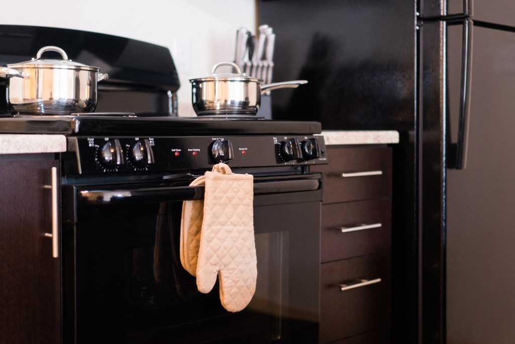 a kitchen with a oven mitt hanging on the oven door