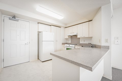 A kitchen with white cabinets and appliances.