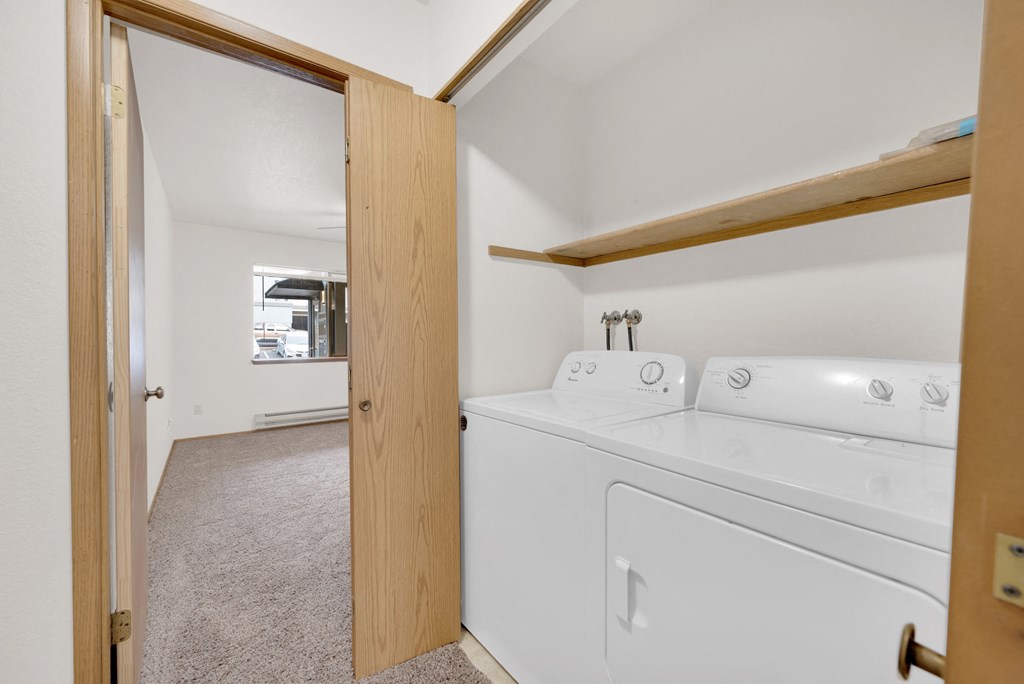 a washer and dryer in a room with a door to a laundry room