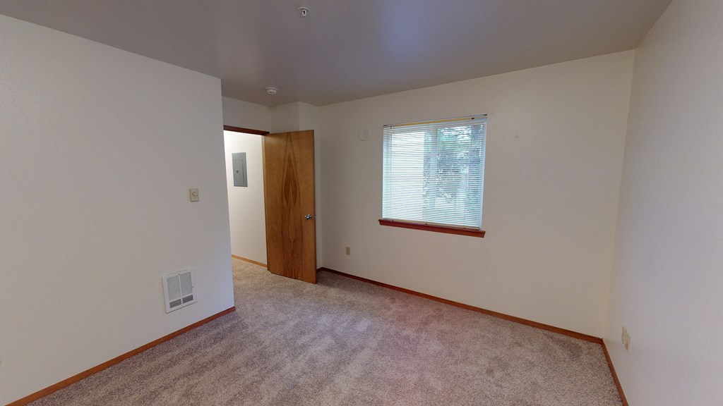 an empty living room with a window and a door
