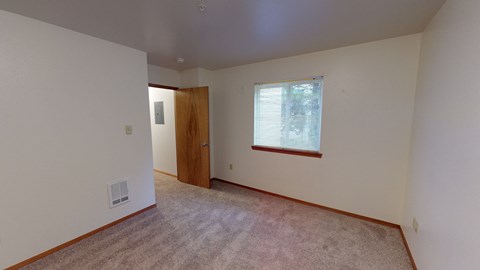 an empty living room with a window and a door