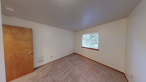an empty room with a wooden door and a window