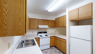 a kitchen with white appliances and wooden cabinets
