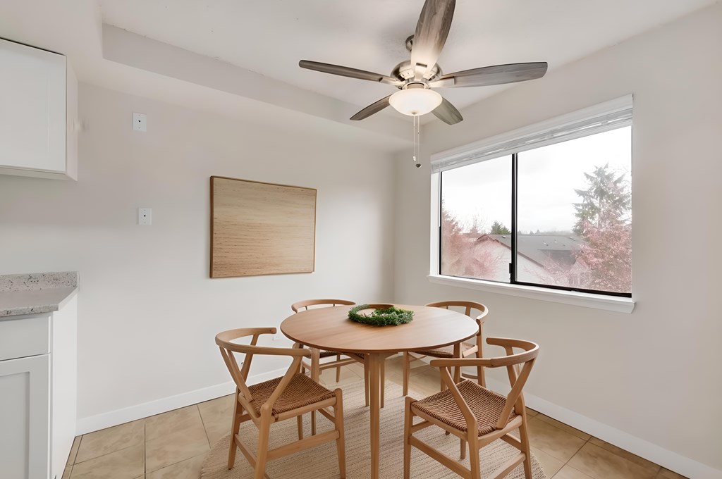 A dining room with a table and chairs.