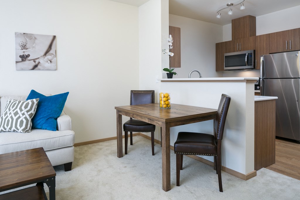 a living room and dining room with a table and chairs and a kitchen