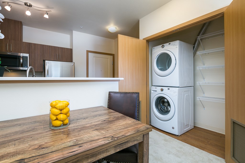 a kitchen with a washing machine and a table and a washer and dryer