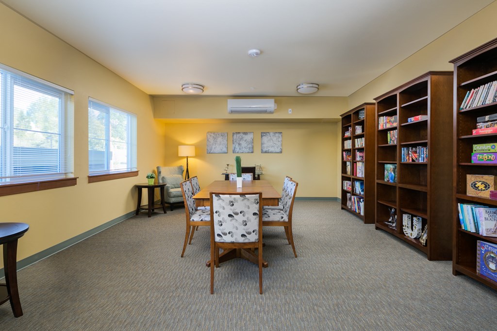 a library with a table and chairs and shelves of books